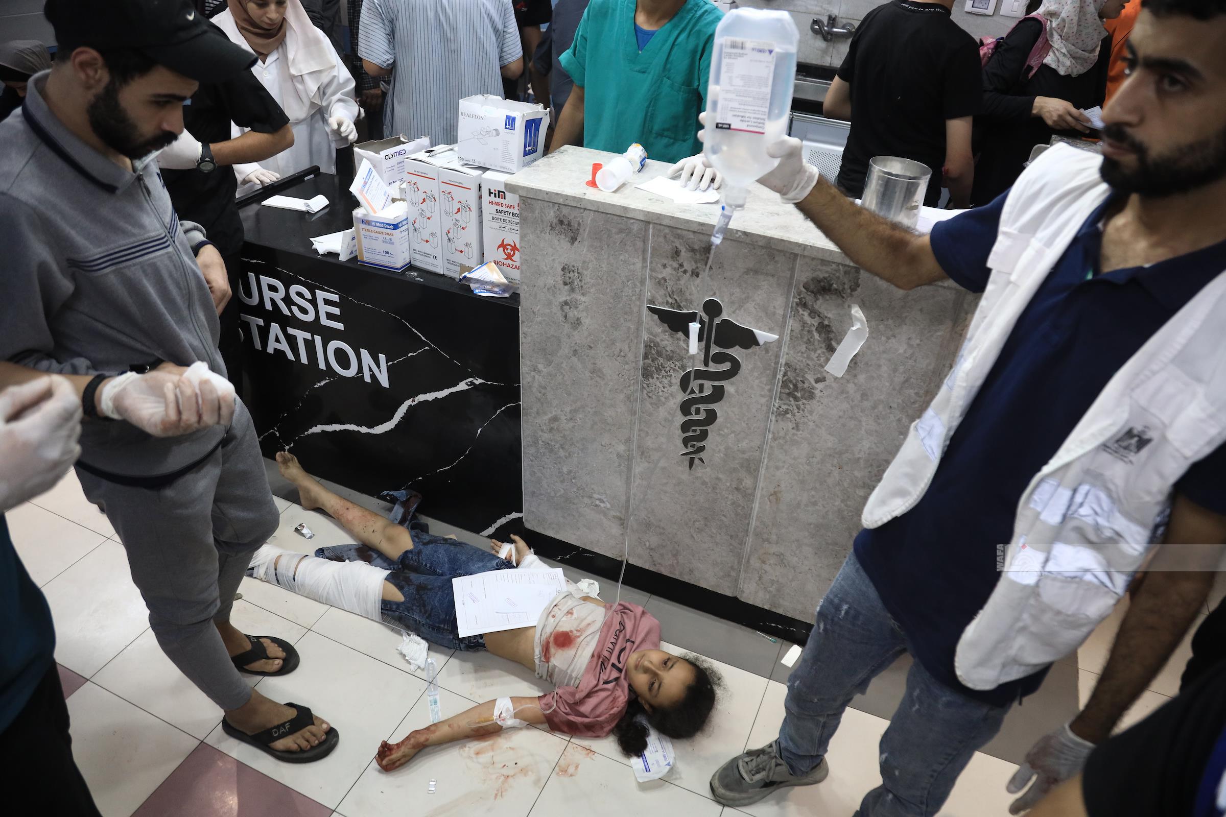 طفلة أصيبت في غارات الاحتلال على منازل المواطنين تتلقى العلاج على الأرض في مستشفى الشفاء في ظل نقص الأسرة والأعداد الكبيرة من الجرحى (تصوير: وفا)